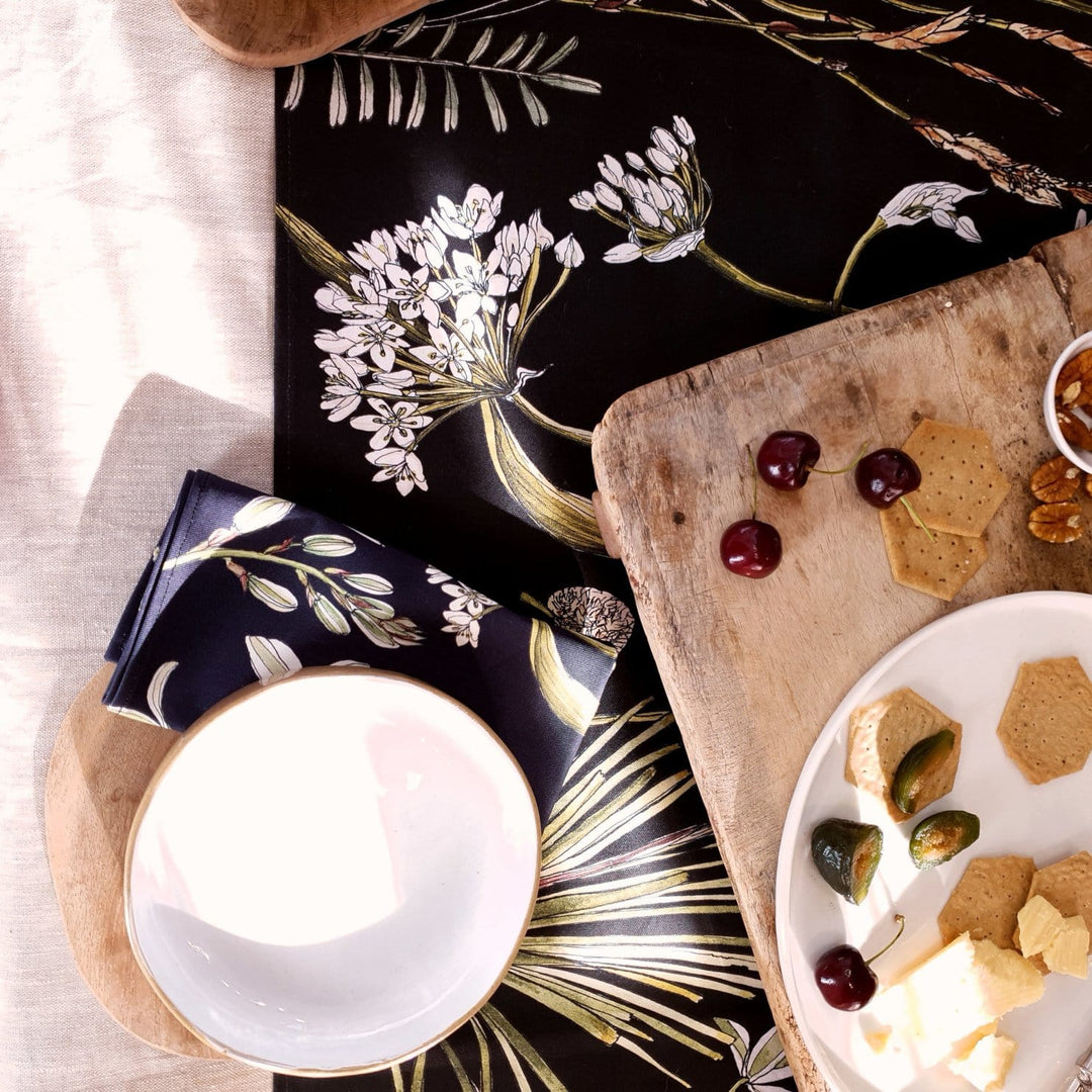 CoralBloom cotton table runner printed with greenery botanicals on black